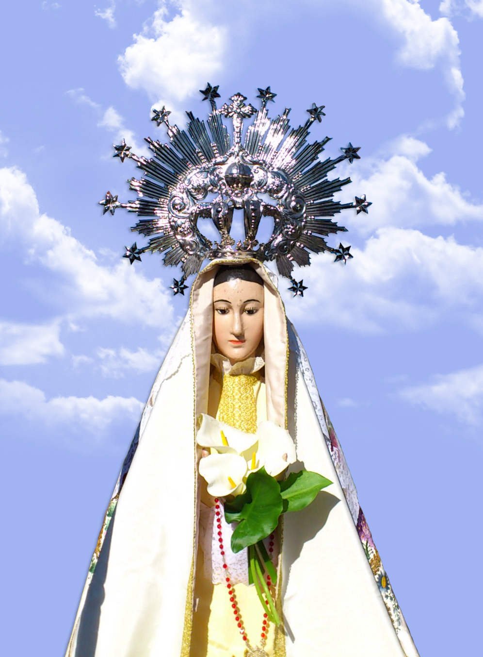 imagen de la virgen con fondo de azulado de nubes blancas